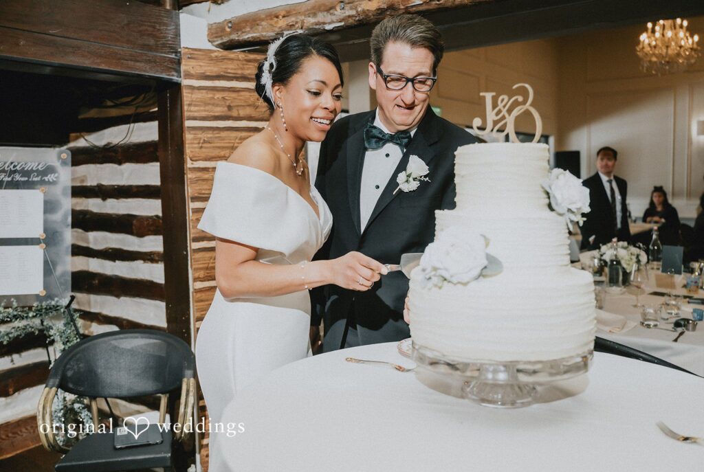 Romantic wedding photo of bride and groom cutting their cake together at Cedar Knoll