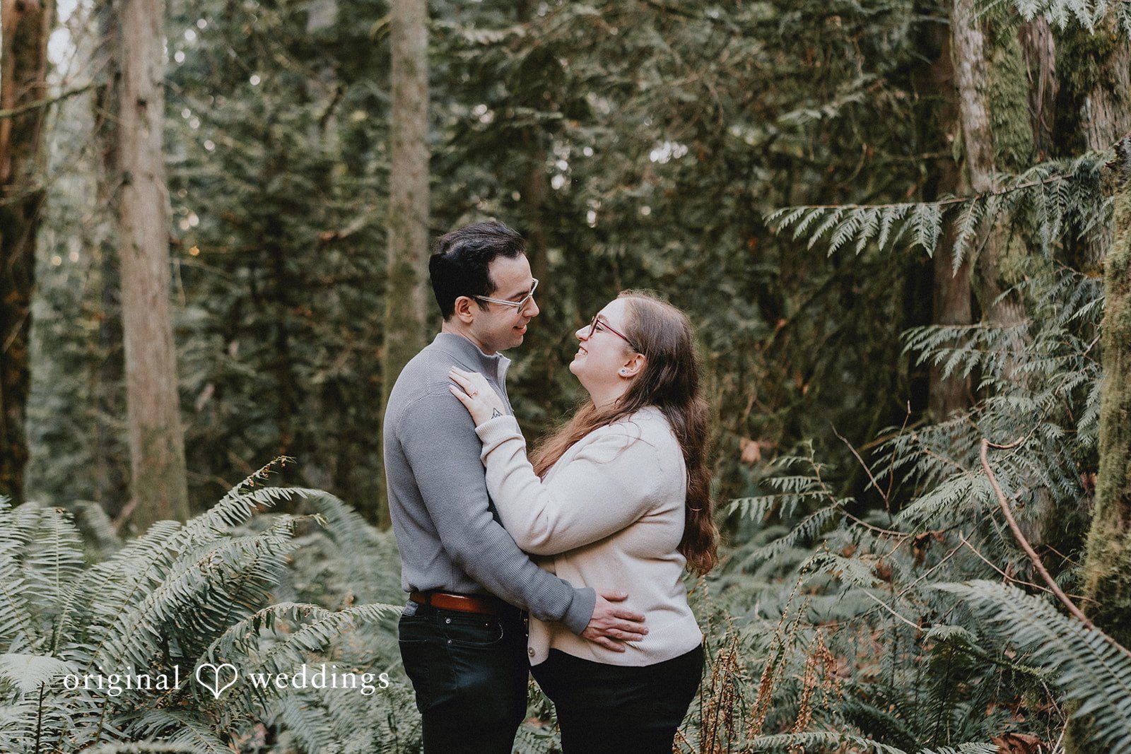 Couple smiling at each other, sharing a sweet moment.