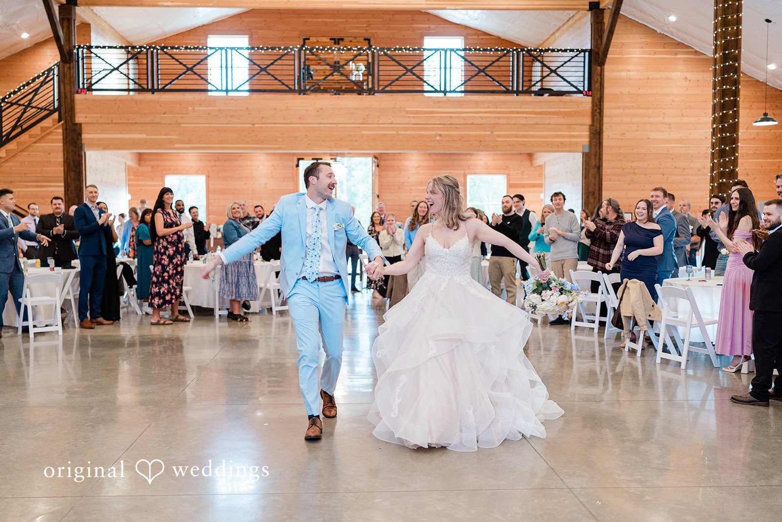 Aubrey + Casey The newlyweds walk hand in hand into the reception while guests watch happily.