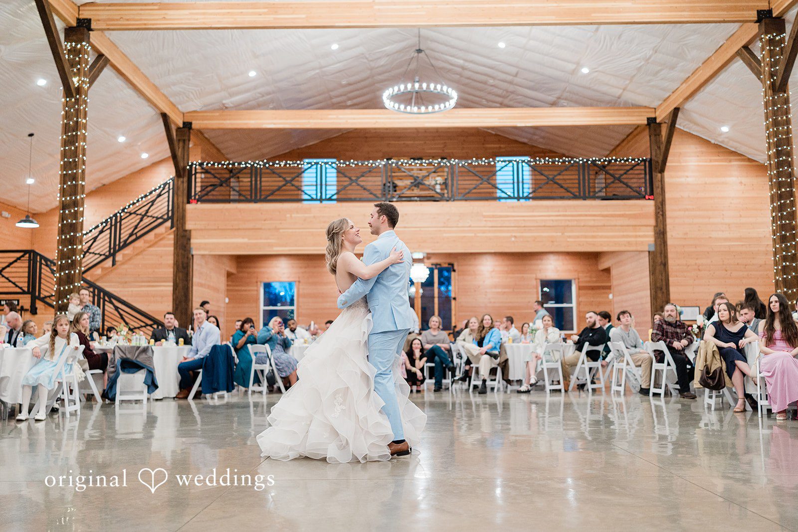 Aubrey + Casey The couple shares their first dance in a spacious and warmly lit reception hall.