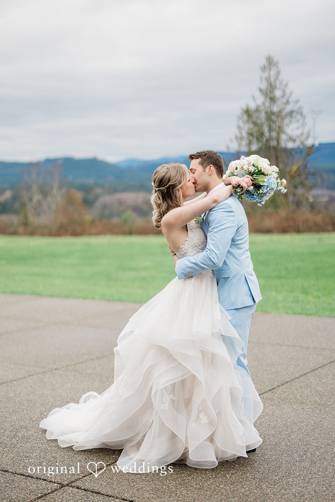 Aubrey + Casey The groom lifts the bride joyfully as they celebrate outdoors.