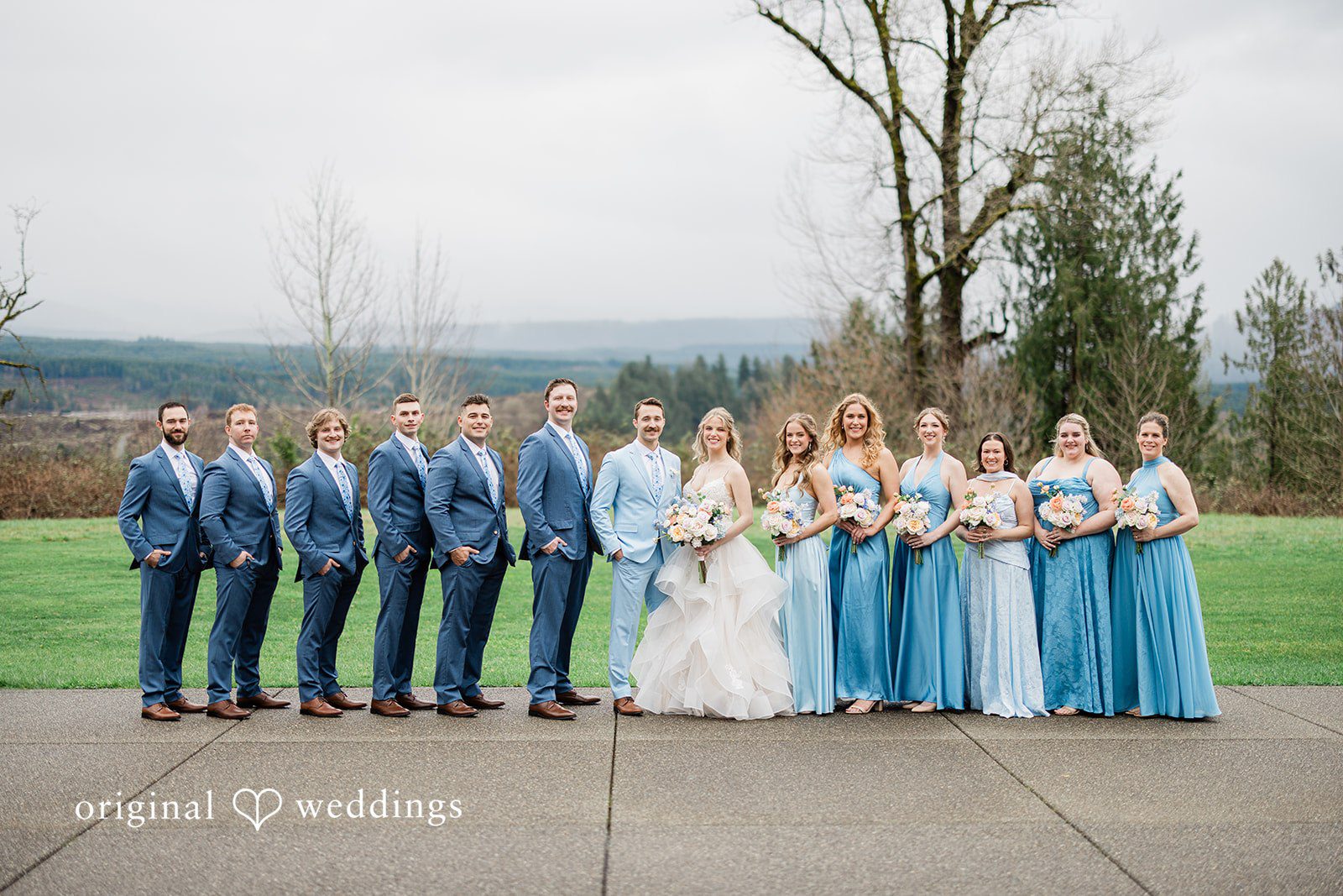 Aubrey + Casey The wedding party stands together outdoors, posing elegantly for a group photo.