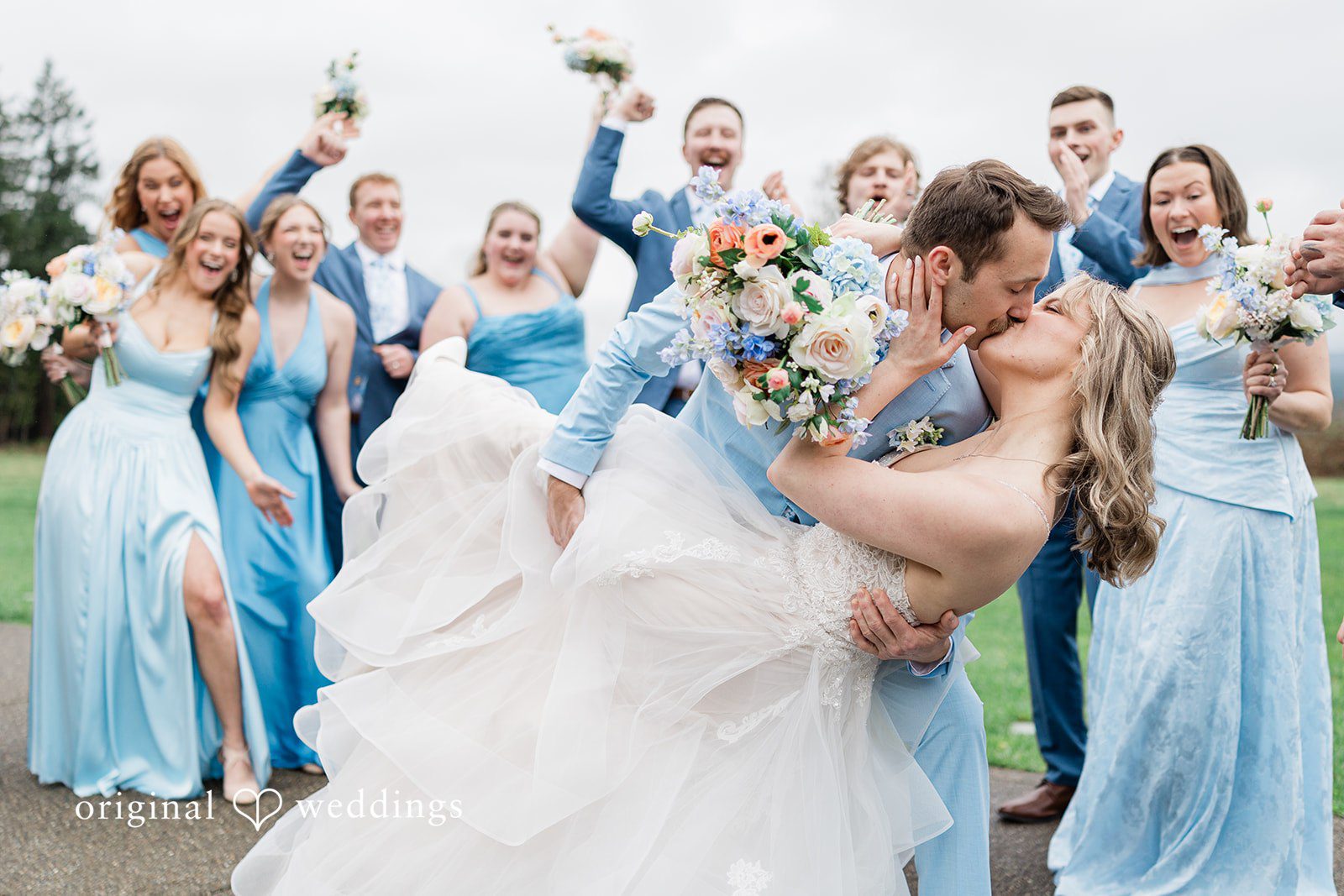 Aubrey + Casey The groom dips the bride dramatically as their friends cheer around them.