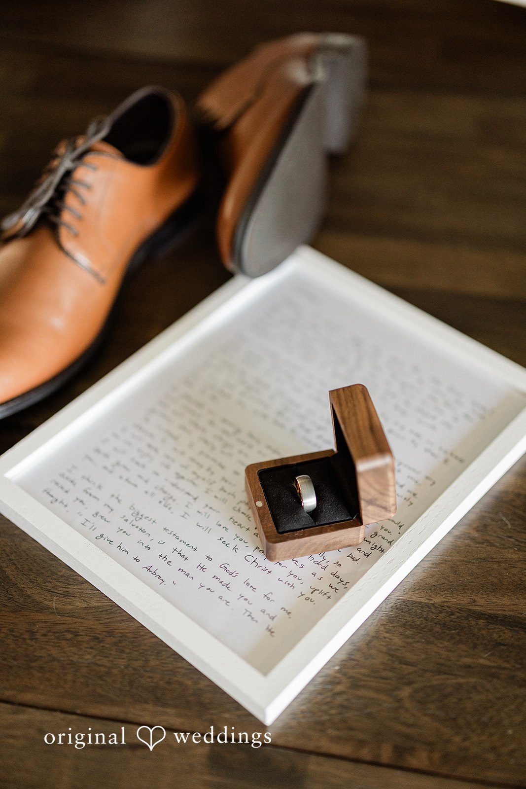 Aubrey + Casey Wedding details including rings and shoes are beautifully arranged on a wooden surface.