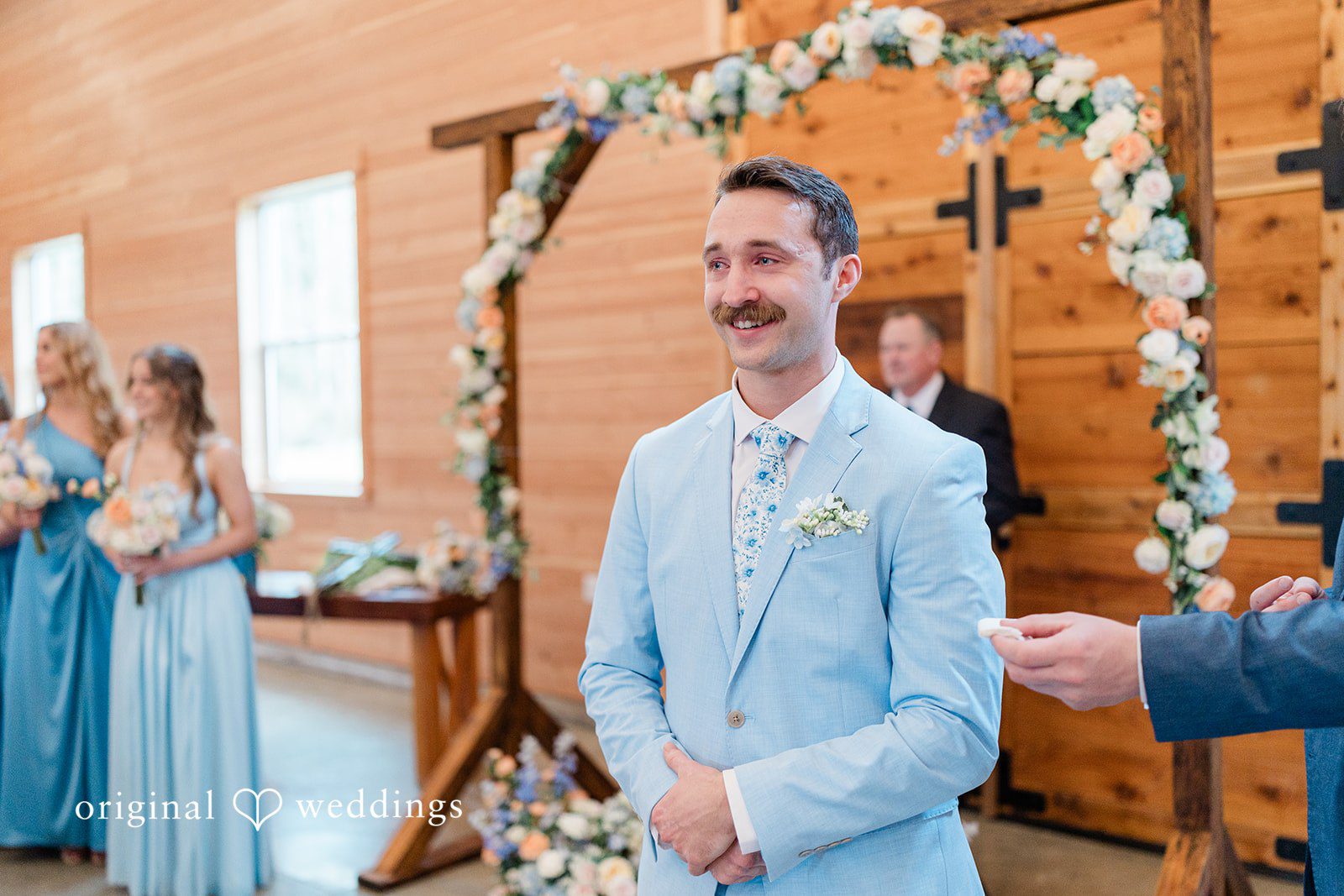Aubrey + Casey The groom stands at the altar smiling during the ceremony.
