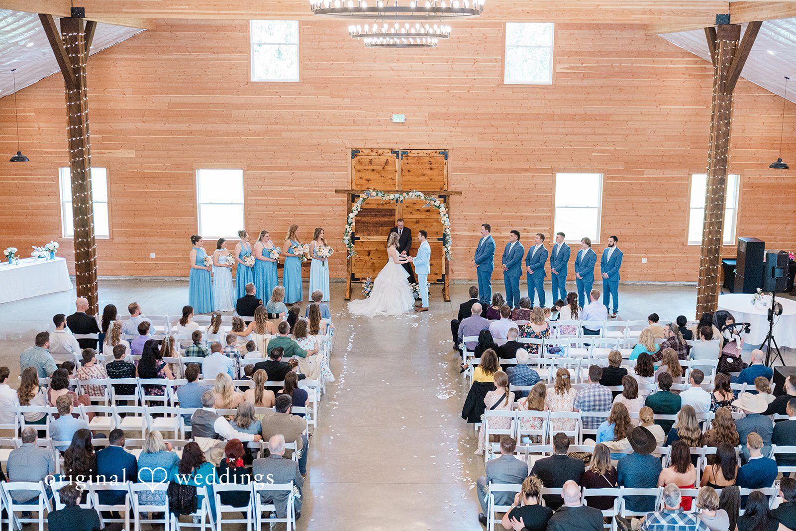 Aubrey + Casey The couple stands at the altar during a beautiful indoor ceremony surrounded by their guests, captured in timeless Seattle wedding photography style.