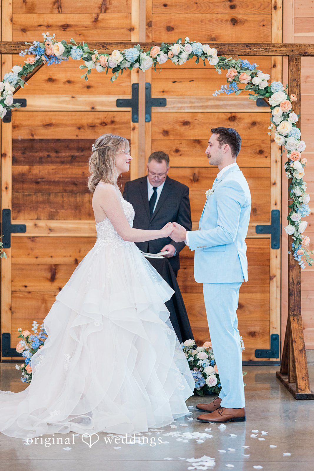 Aubrey + Casey The couple exchanges vows under a floral arch during their ceremony.
