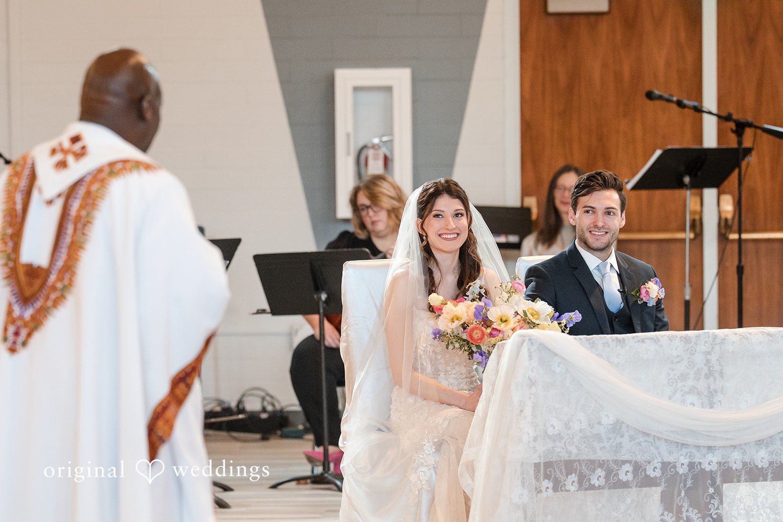 Kelsey + Jensen Elegant wedding portrait of couple sitting in front of priest at Edmonds Waterfront Center