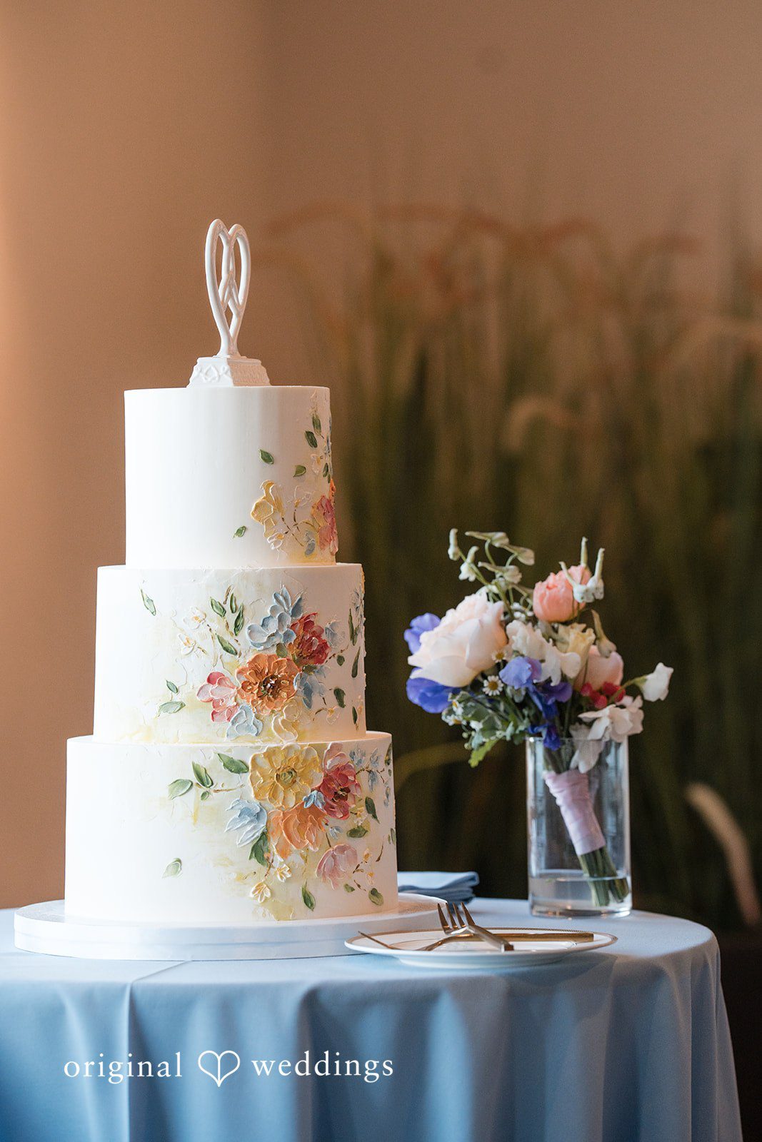 Kelsey + Jensen Elegant wedding cake adorned with floral decorations at Edmonds Waterfront Center