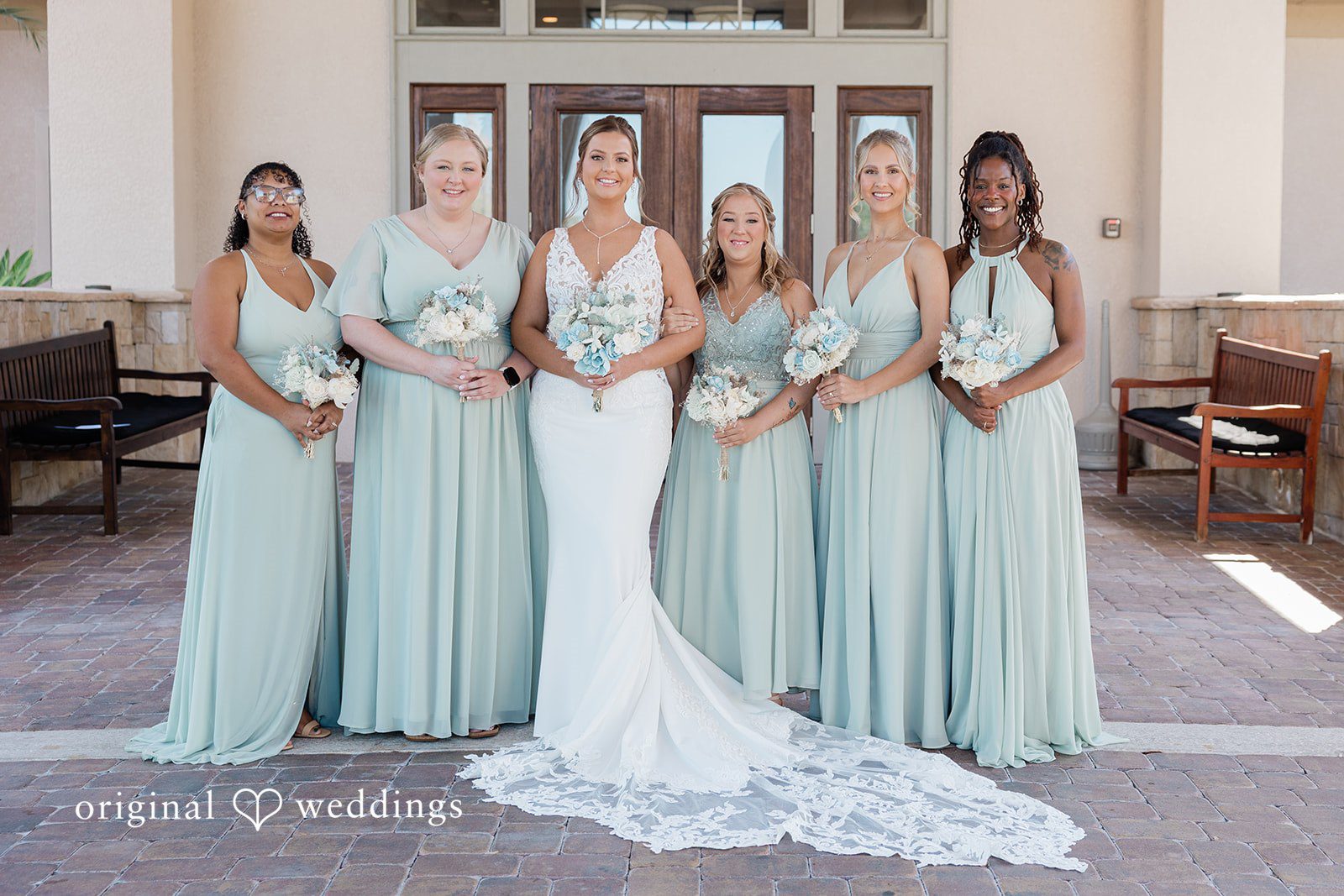 Lovely picture of bride with bridesmaids after getting ready with bouquet of flowers