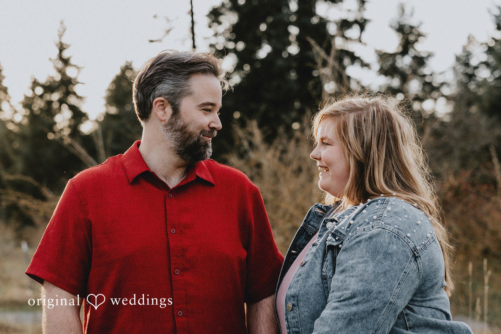 Engagement photography services by Original Weddings capturing smiling couple looking at each other at Hidden Farm & Stables