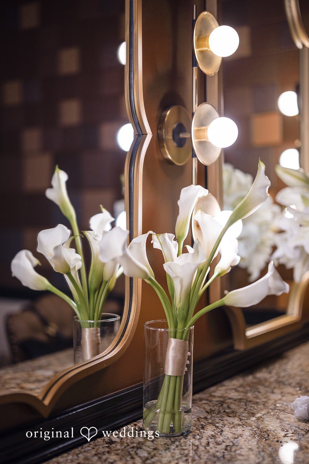 Patrick + Barbara Jean White floral arrangement placed beside a softly lit vanity mirror.
