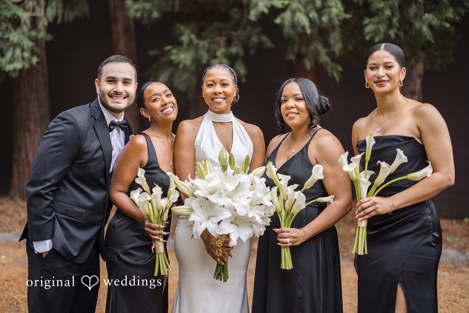 Patrick + Barbara Jean Bride smiling with her bouquet, standing between two bridesmaids.