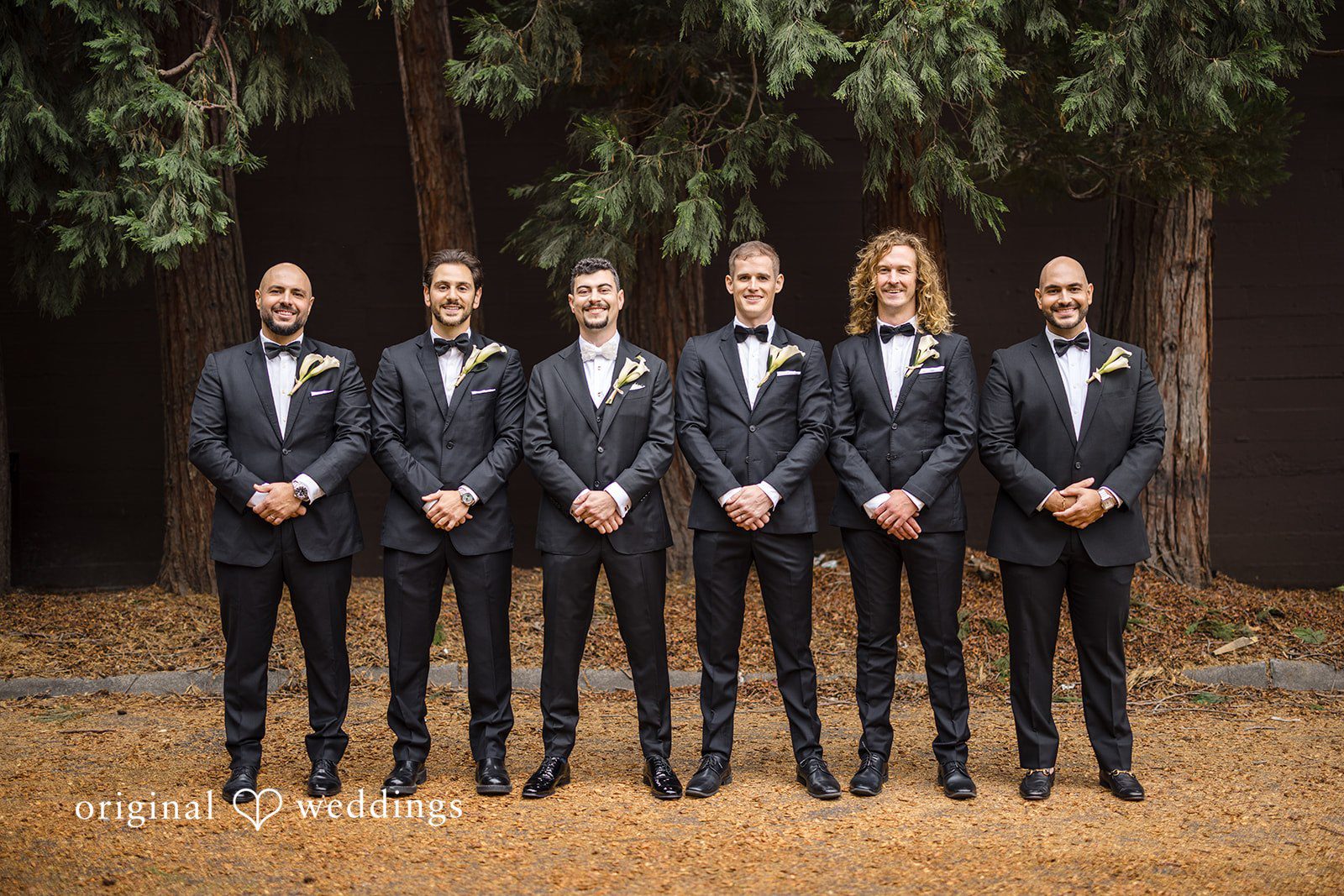 Patrick + Barbara Jean Groom and groomsmen standing side by side, looking at the camera for a formal group portrait.