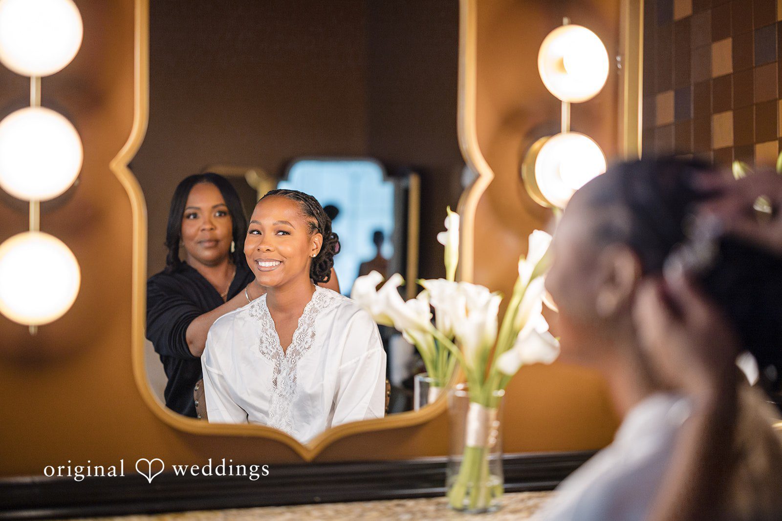 Patrick + Barbara Jean Bride reflected in a mirror while getting ready with assistance.