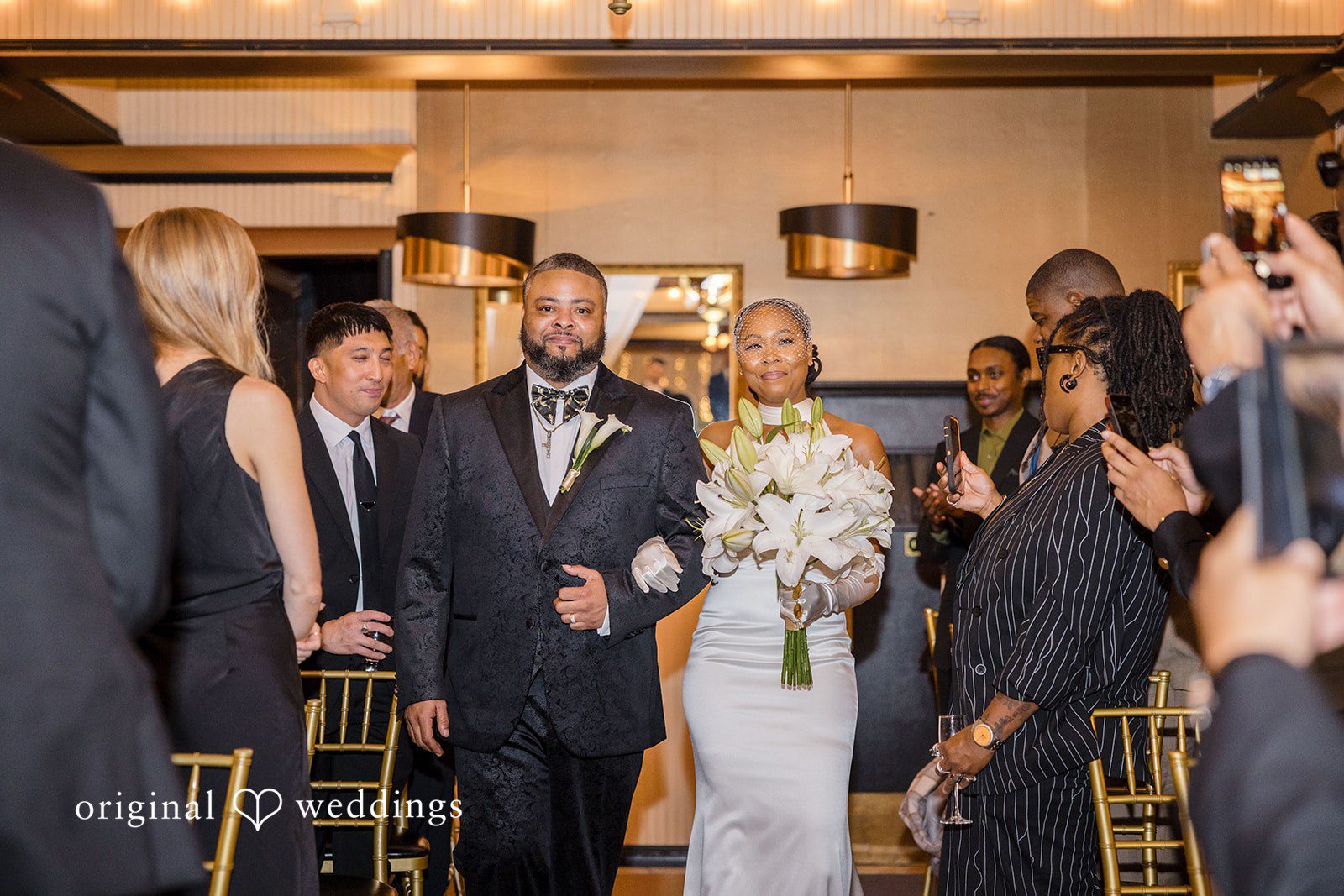 Patrick + Barbara Jean Couple entering the reception area surrounded by guests.