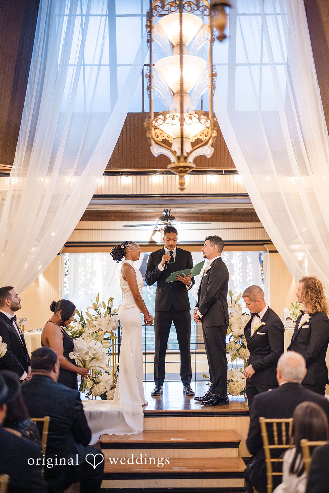 Patrick + Barbara Jean Bride and groom standing at the altar with wedding guests seated behind them.