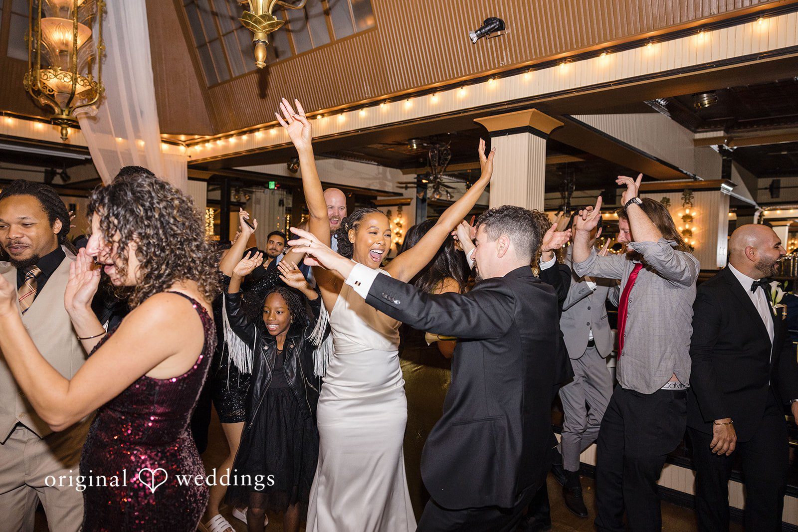 Patrick + Barbara Jean Bride dancing energetically on the dance floor surrounded by guests.