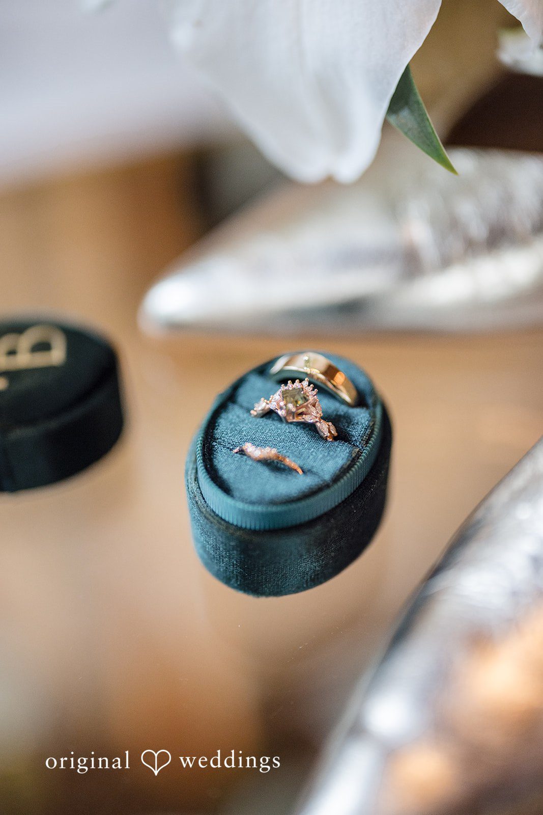 Patrick + Barbara Jean Close-up of wedding rings in a teal box during preparation.