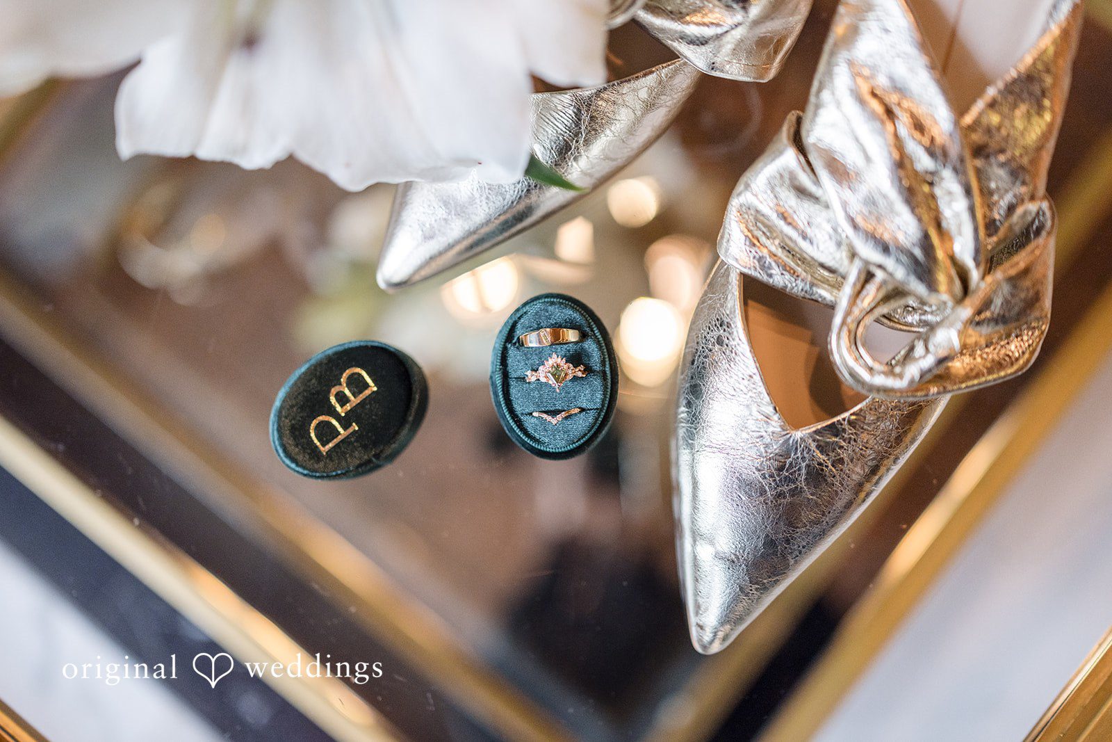 Patrick + Barbara Jean Bride’s shoes and jewelry arranged elegantly on a reflective surface.