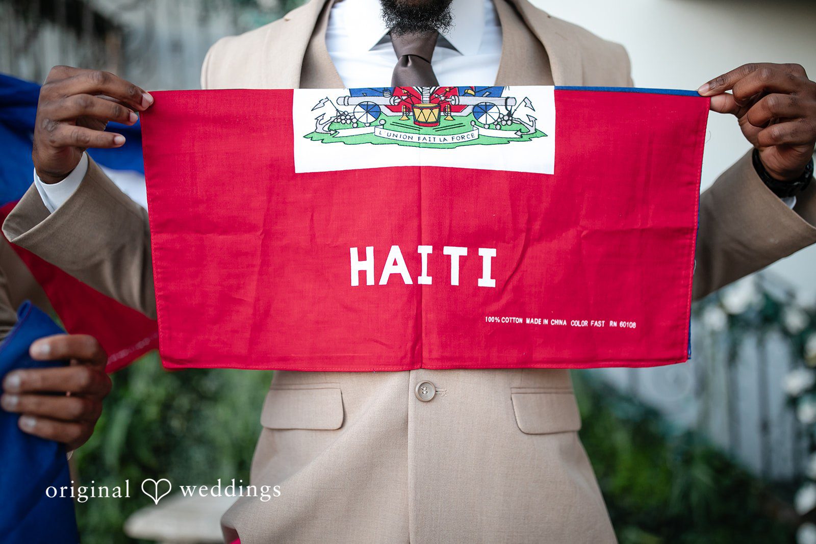 Whitchyna + Kevin Man holding Haiti flag at wedding