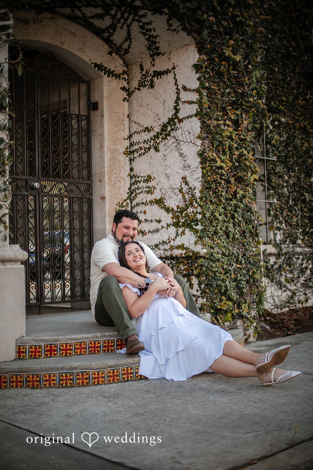 A seated portrait of the couple in front of Kraft Azalea Gardens