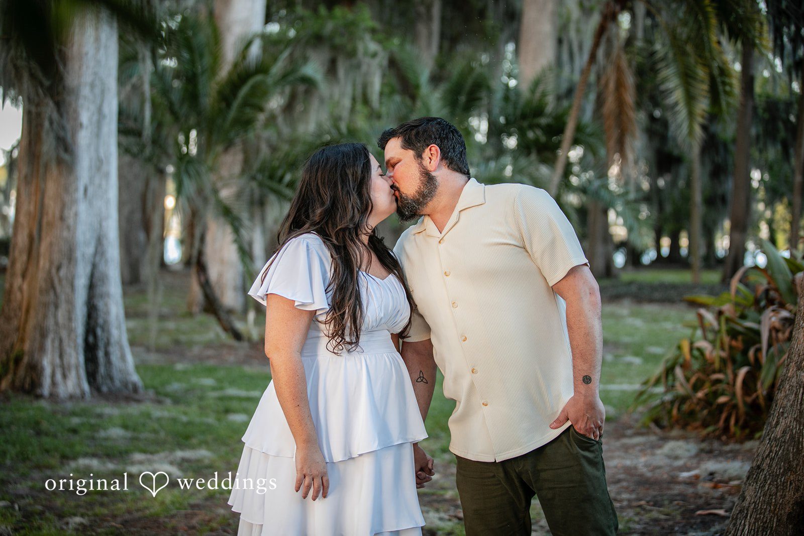 The couple shares a kiss in the garden