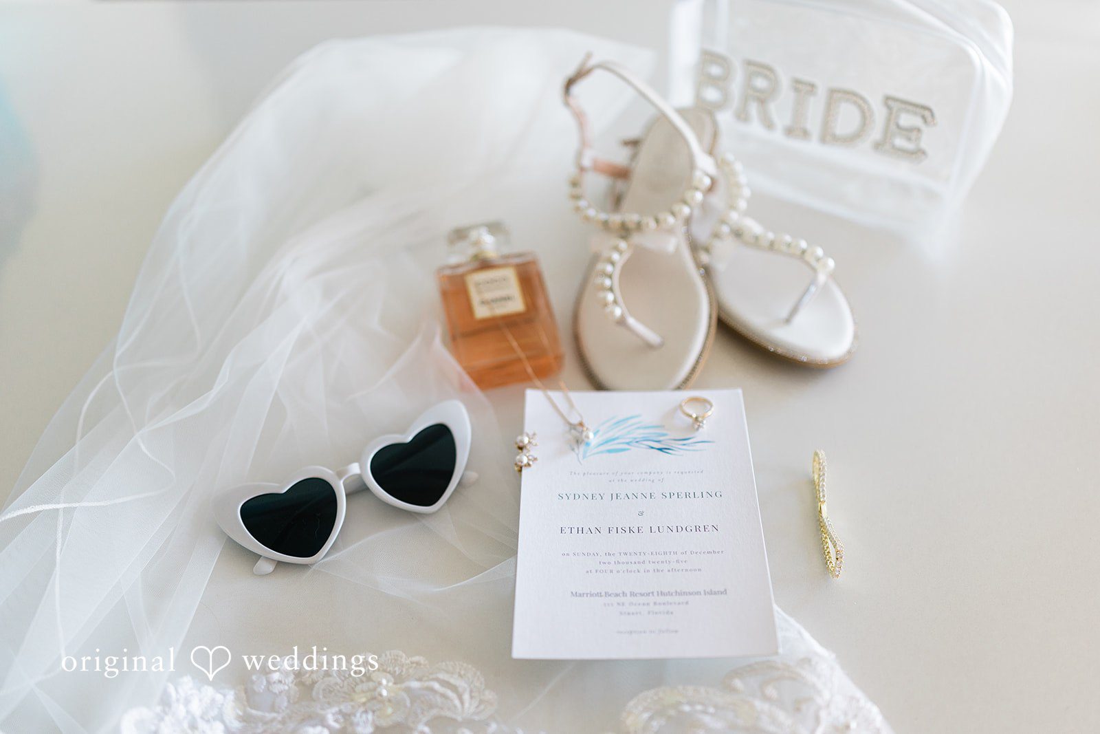 Ethan + Sydney Wedding accessories styled on white fabric.