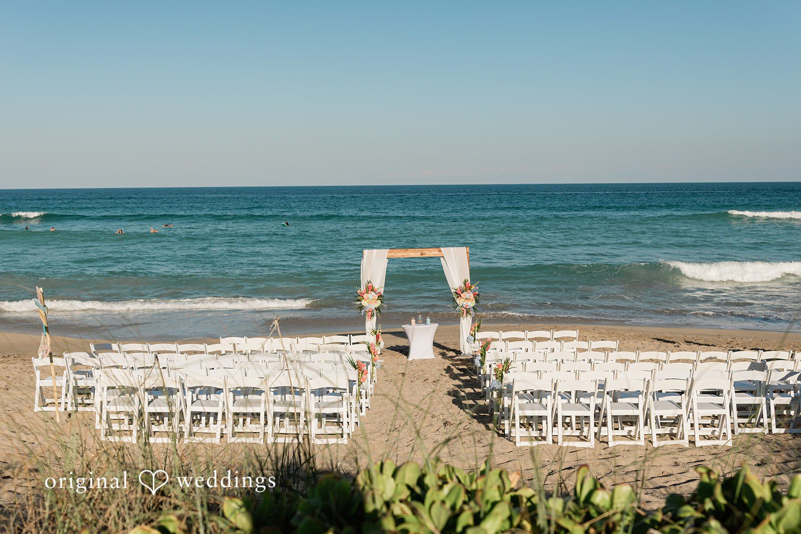Ethan + Sydney Beach ceremony setup with white chairs at Marriott Hutchinson Island Beach Resort.