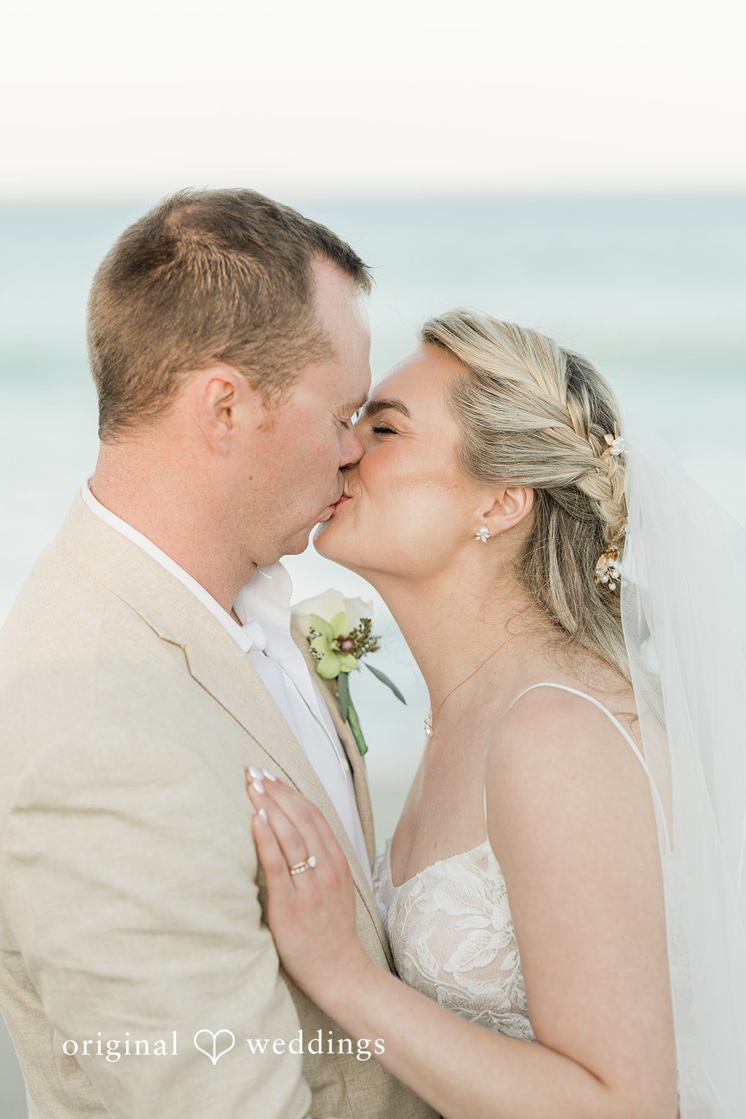 Ethan + Sydney Couple kissing during beach wedding ceremony.