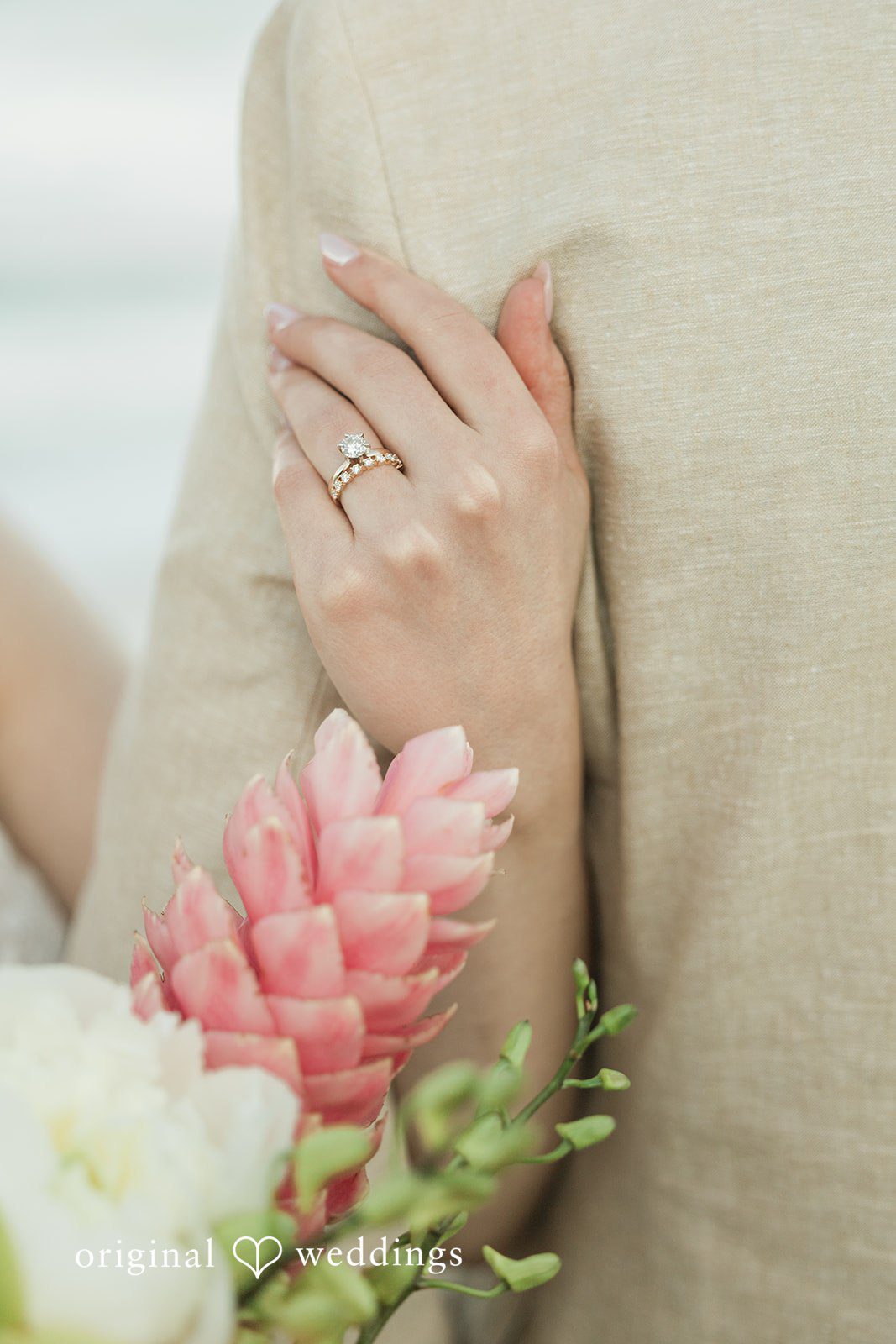 Ethan + Sydney Close-up of hands with wedding rings and bouquet.