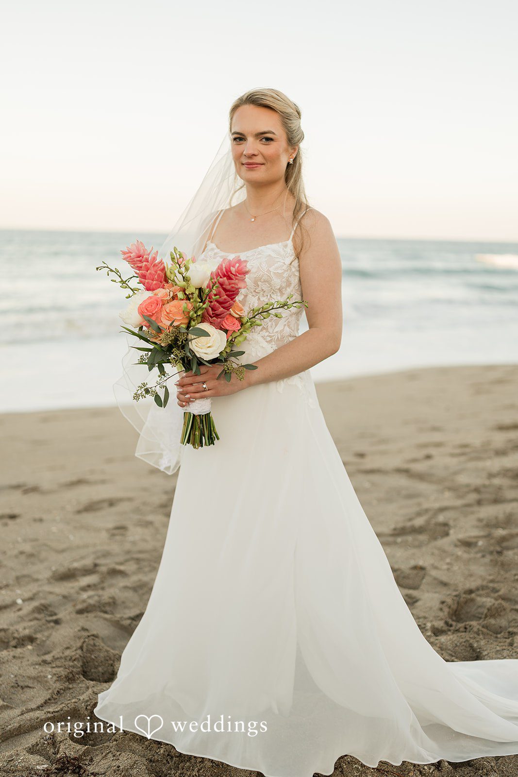 Ethan + Sydney Stunning Look of Bride posing on beach with bouquet