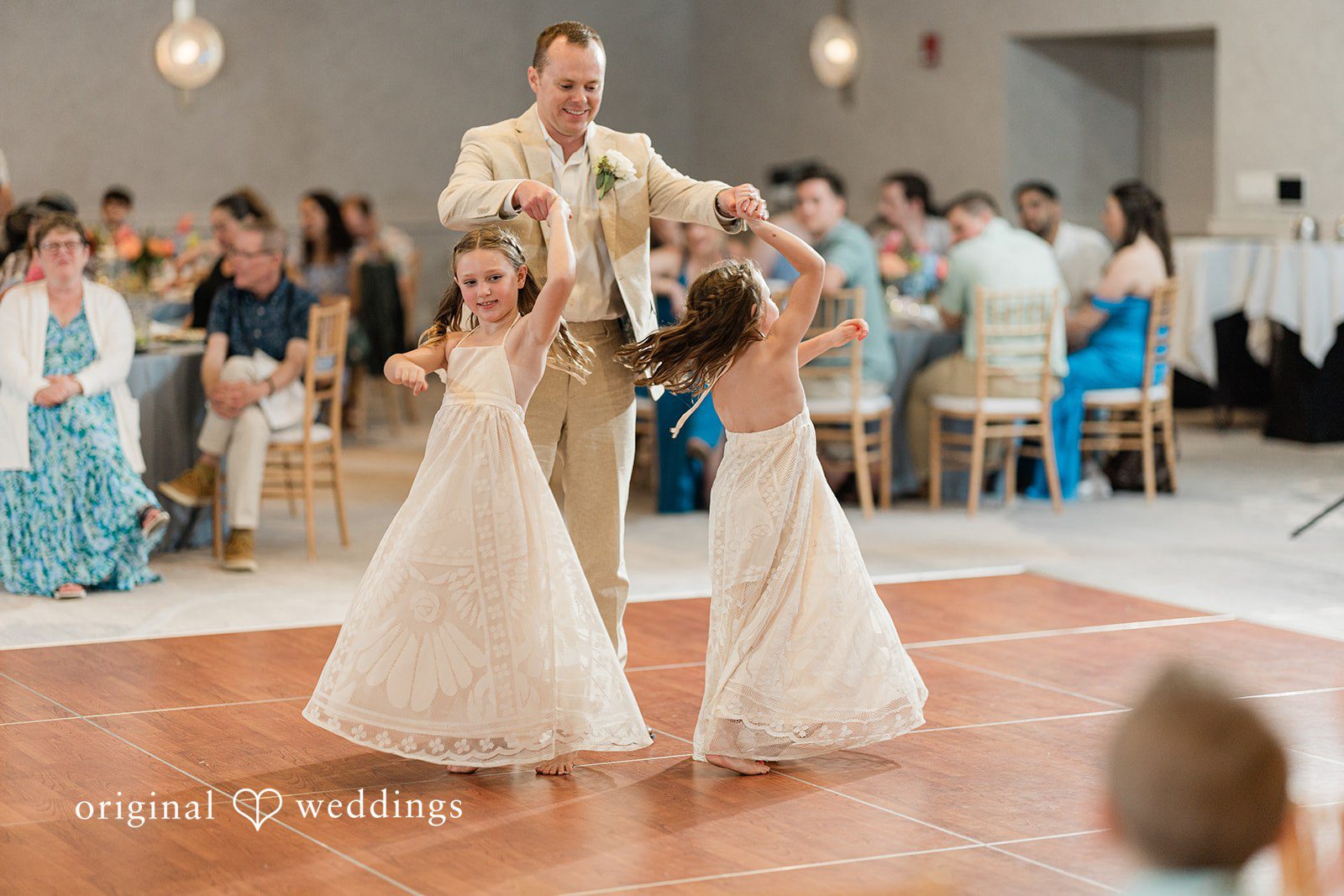 Ethan + Sydney Groom dances with two girls in white dresses on a wooden floor at Marriott Hutchinson Island Beach Resort.