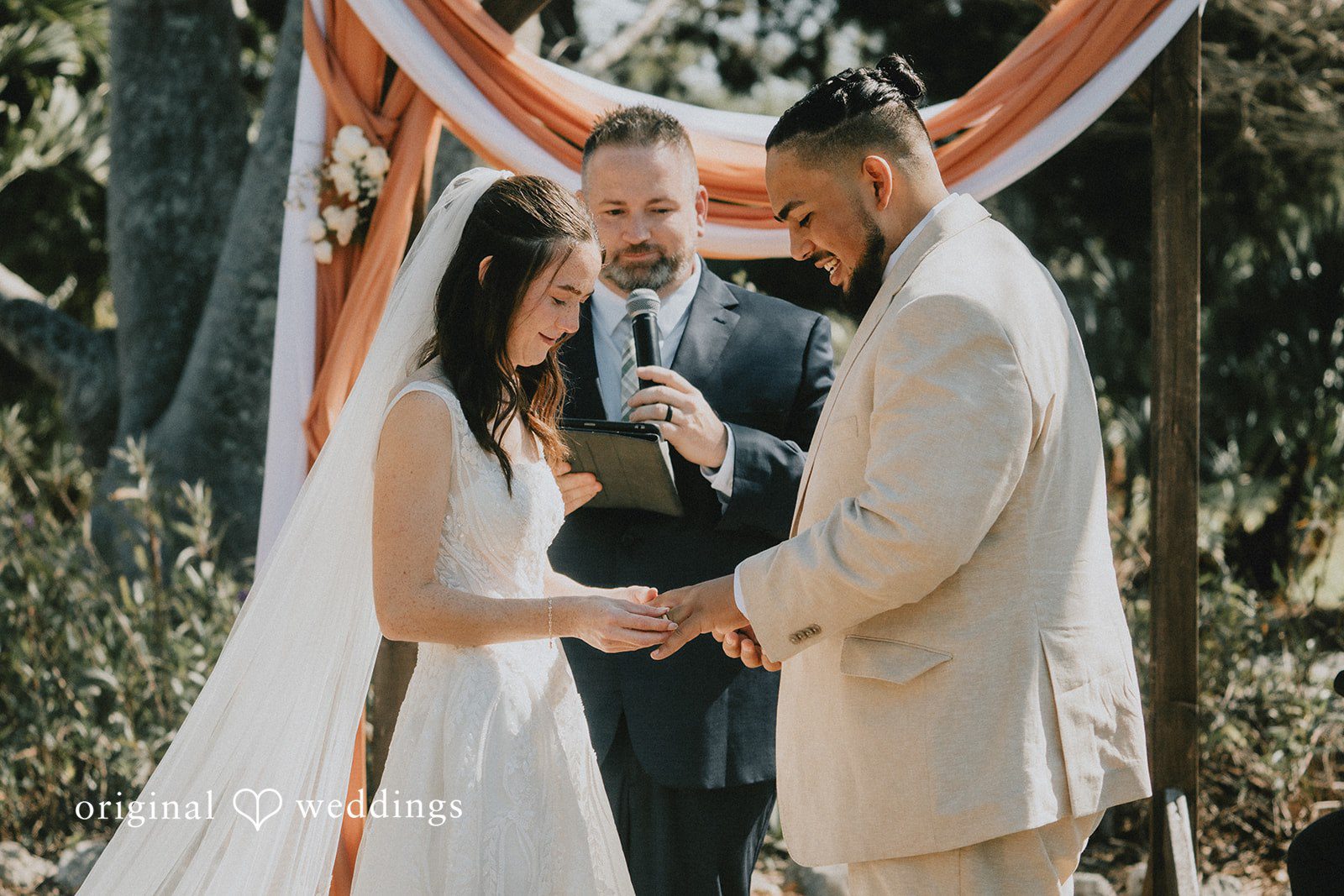 The bride and groom exchange wedding rings