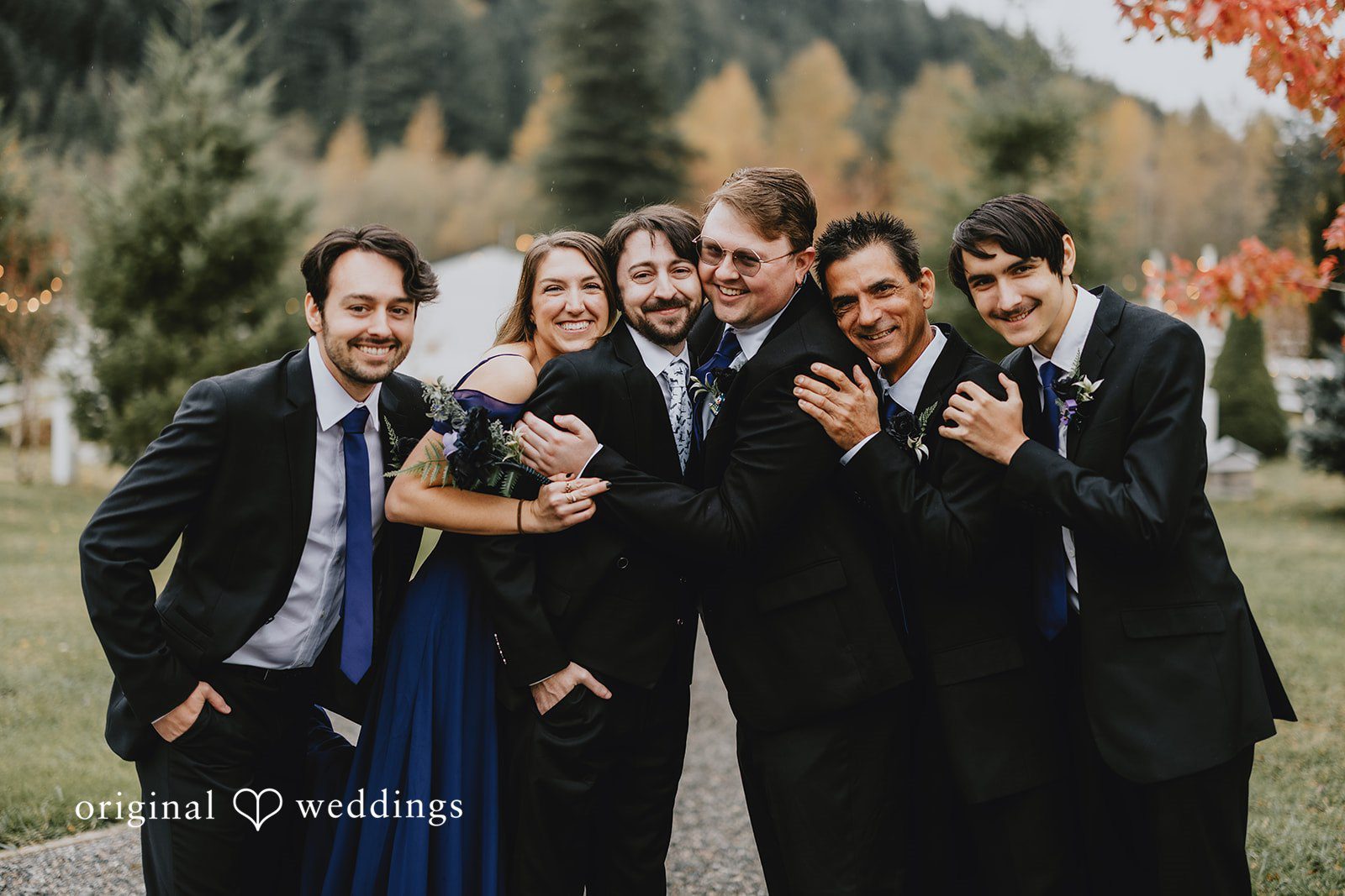 An outdoor group portrait of the wedding party captures energy and togetherness in a natural setting.