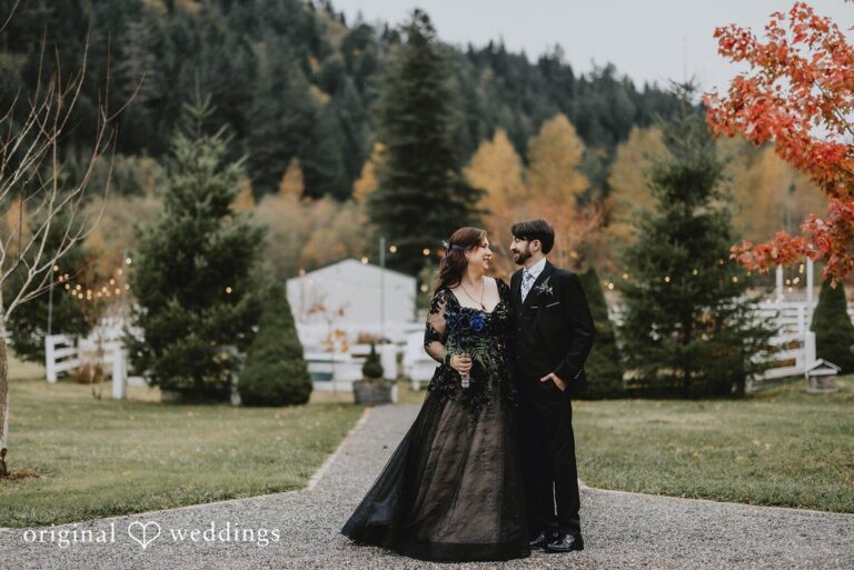 Seattle wedding photography of McKenna and Tim walking together at Rein Fire Ranch with autumn trees and rustic surroundings near Seattle