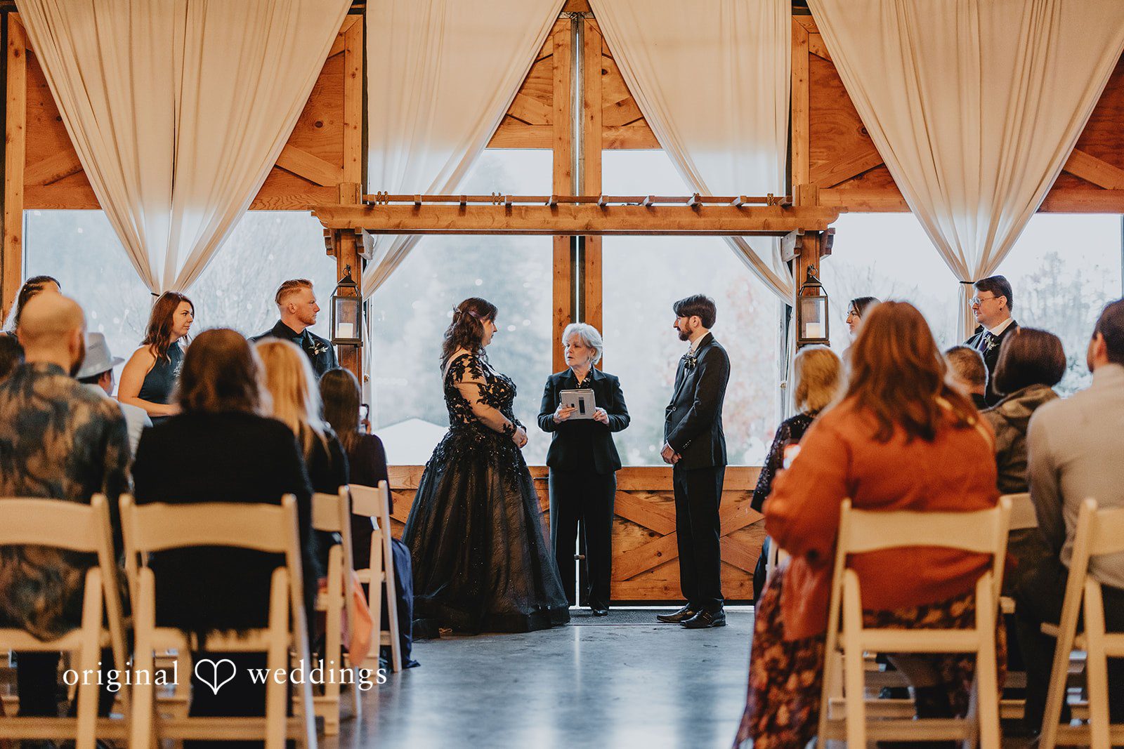 A wedding procession moves through the aisle as guests watch from both sides.