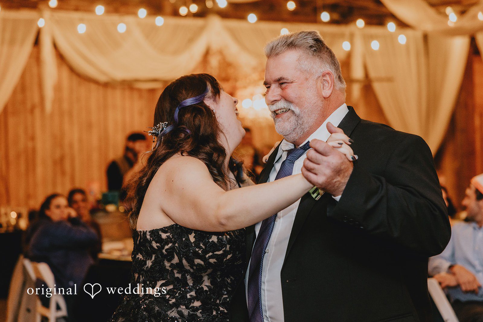A close-up of two people holding hands captures an intimate wedding detail.