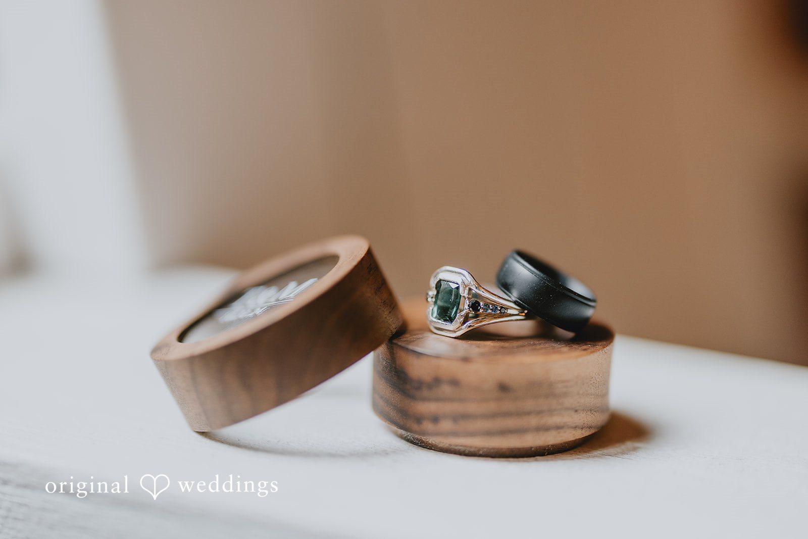 Wedding rings resting inside a small wooden box present a minimalist detail shot.