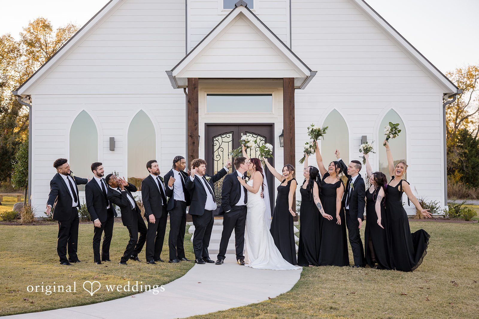 Our Dallas wedding photographer at Original Weddings captured a romantic and joyful portrait of the couple with their bridal party at the River Road wedding venue
