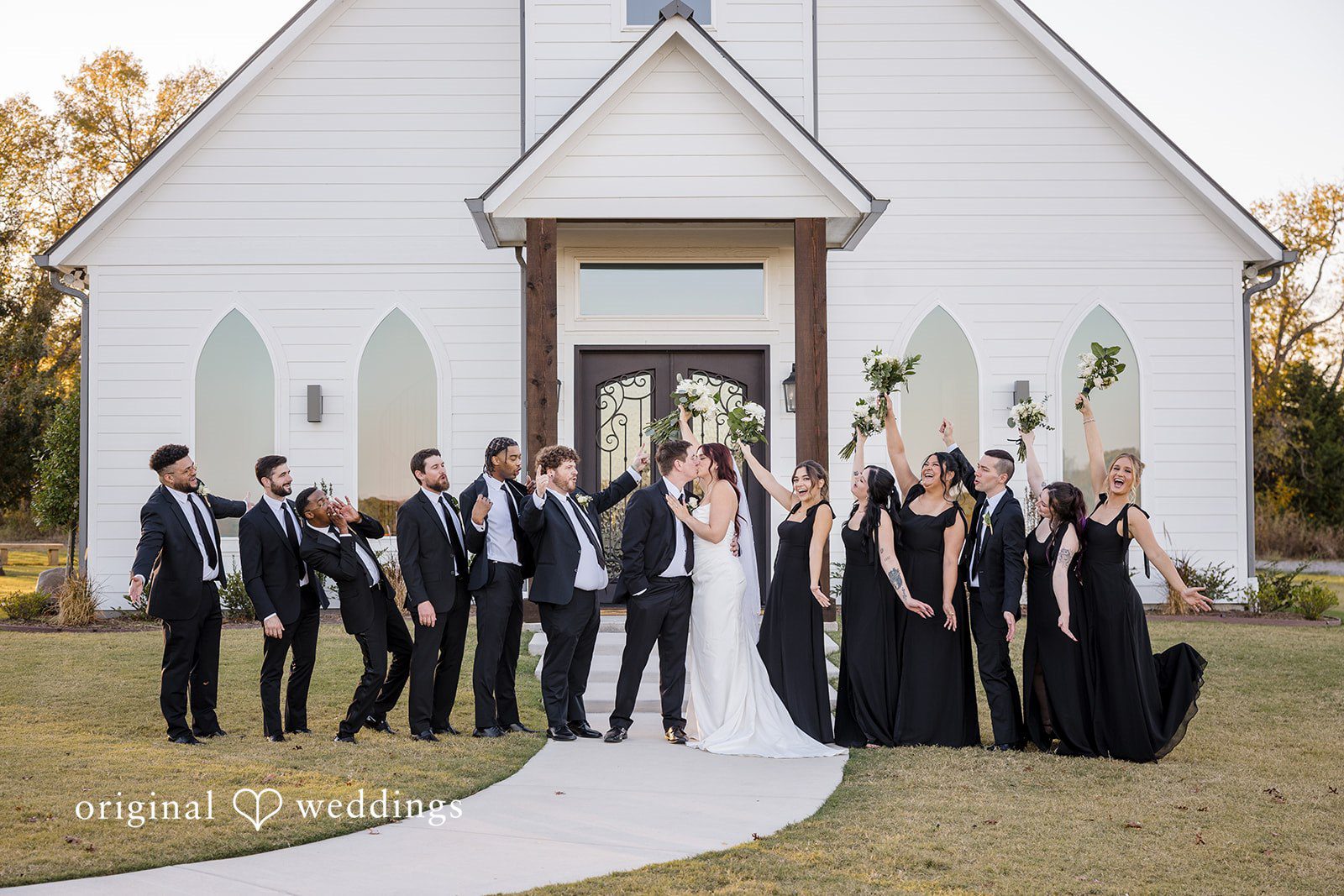 Our Dallas wedding photographer at Original Weddings captured a romantic and joyful portrait of the couple with their bridal party at the River Road wedding venue