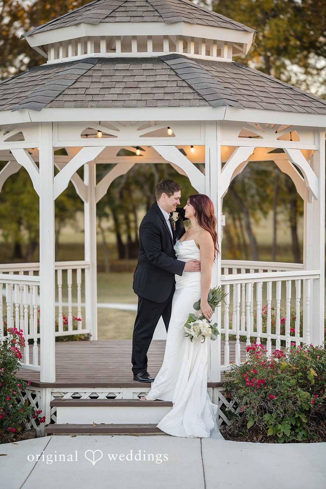 A romantic portrait of the couple by the gazebo at the River Road