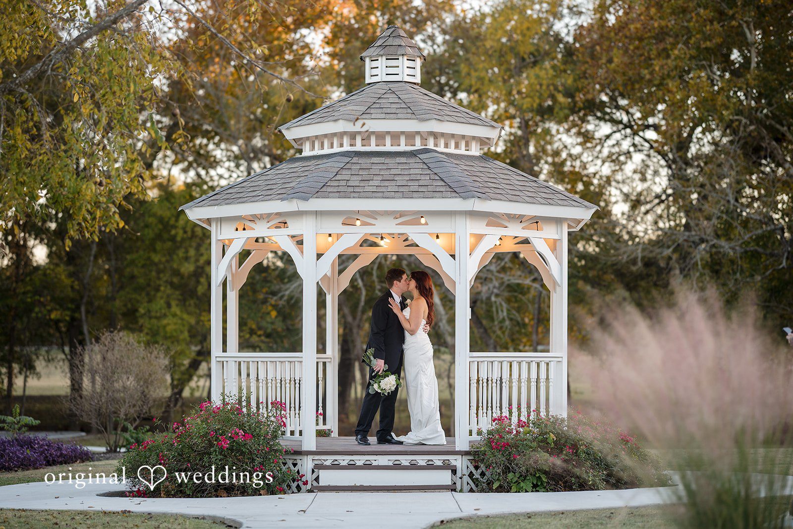 The couple shares a romantic kiss at the gazebo