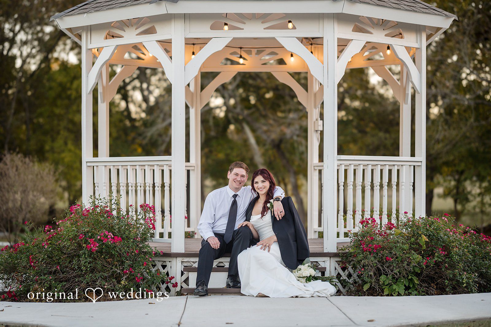 A beautiful portrait of the couple seated by the gazebo at the River Road wedding venue