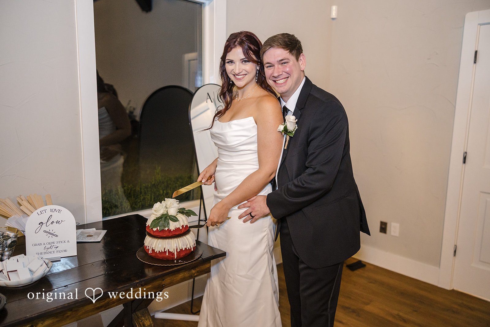 A happy portrait of the couple cutting their wedding cake