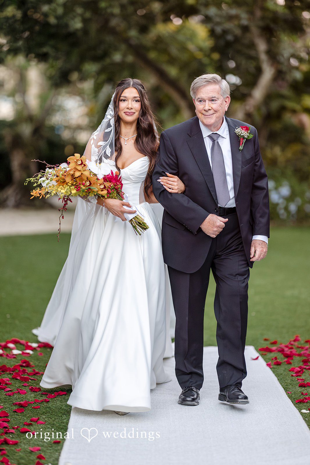 Bride walking down the aisle with a family member during outdoor ceremony