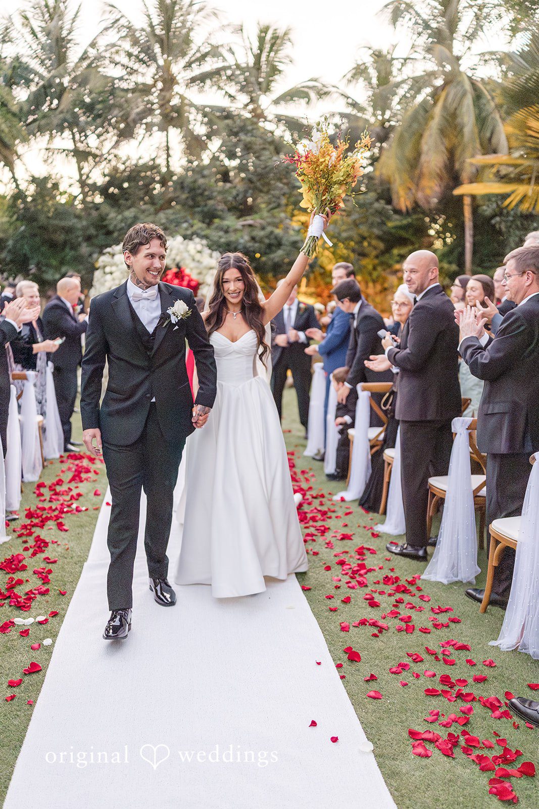 Couple walking back up the aisle as guests celebrate
