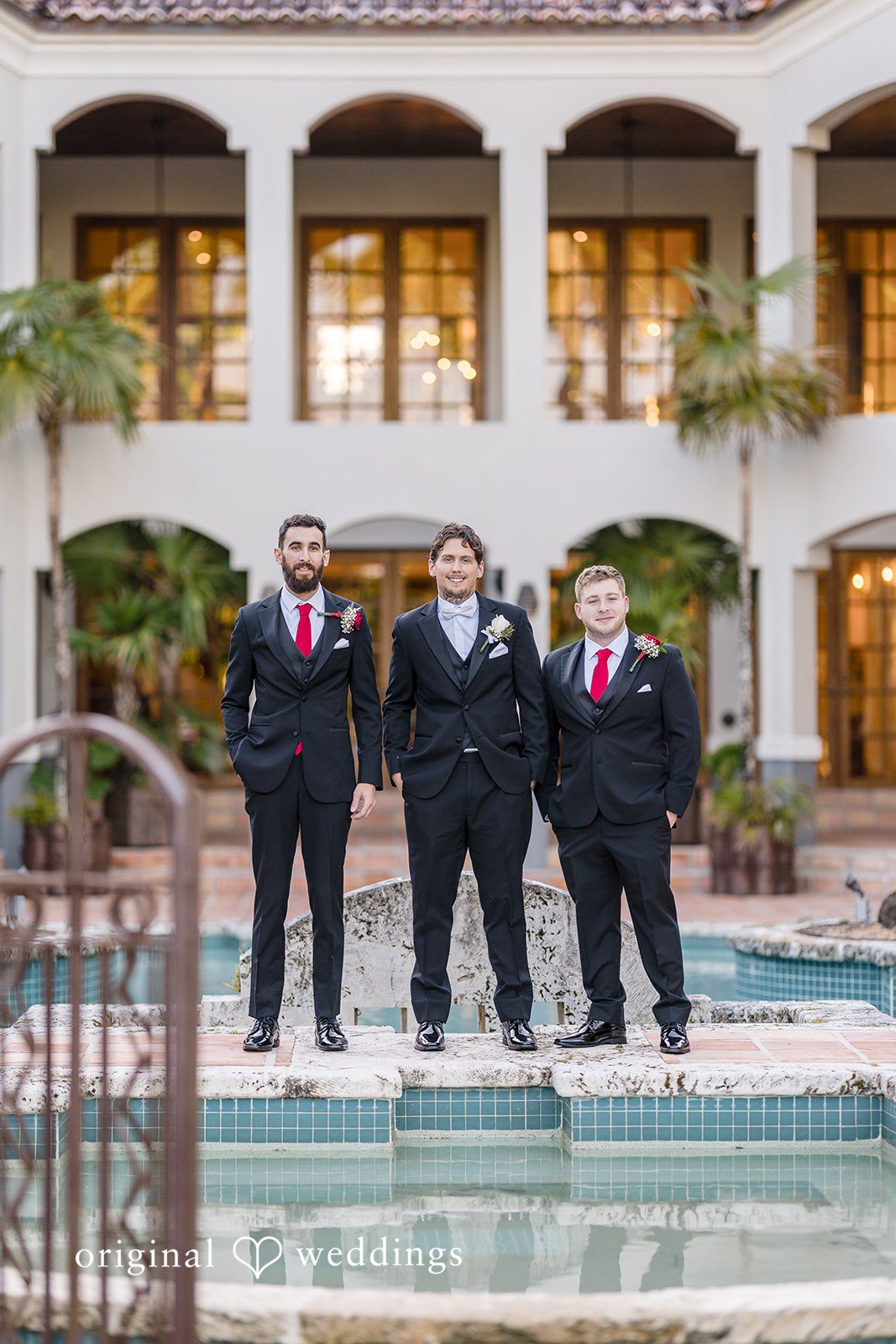 Formal groomsmen portrait by the pool at the wedding venue