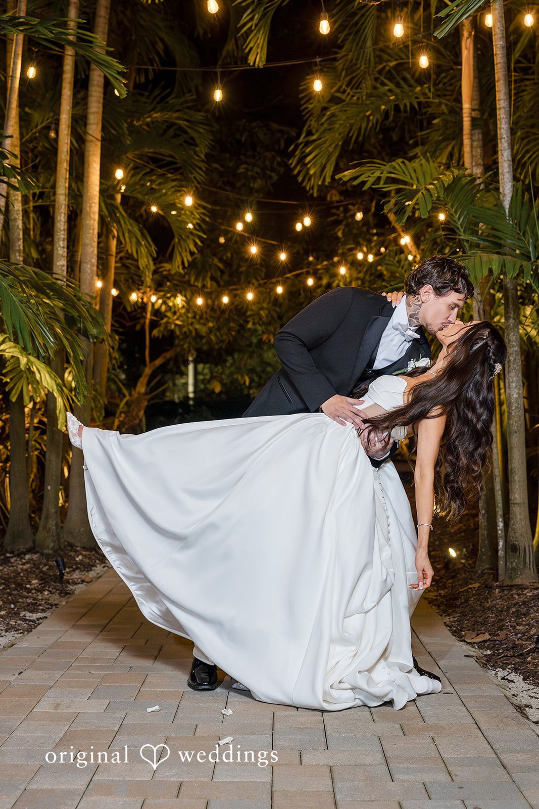 Nighttime portrait of the couple outdoors with string lights