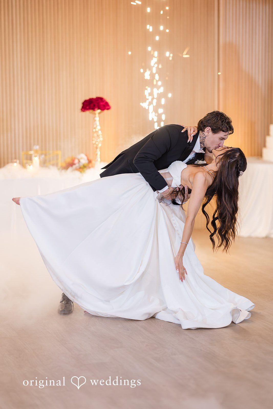 Romantic dance pose during the reception under warm lighting